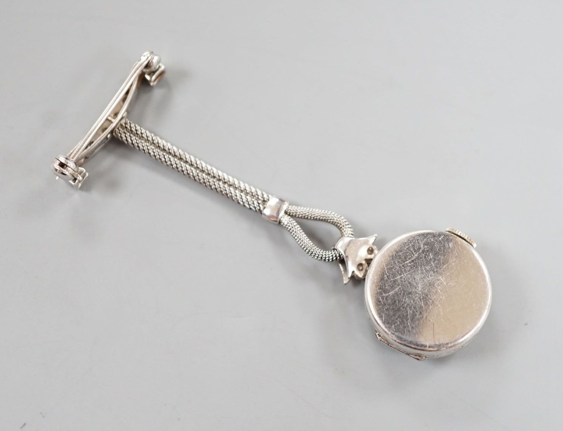 A lady's 1920's white metal (stamped platinum) and diamond chip set lapel watch, 6cm, gross weight 10.7 grams.